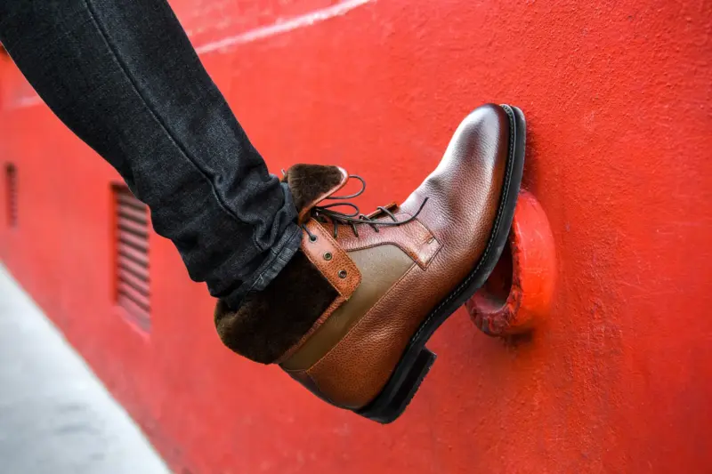 Bottine LodinG en cuir posée contre un mur rouge
